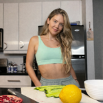Karina Vee in her kitchen with fresh veggies and fruits.